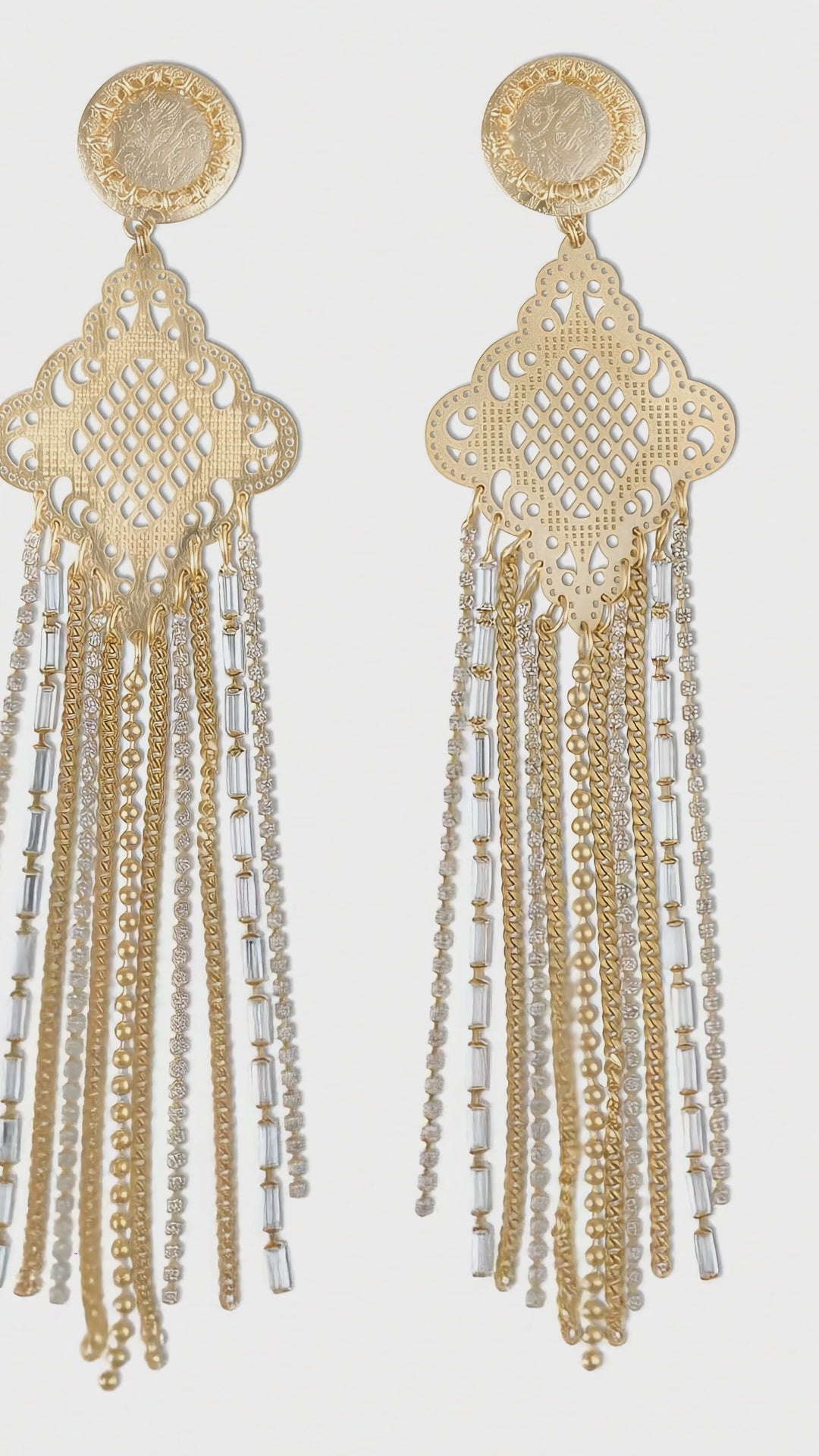 Load video: Orecchini in metallo finitura argento con piastra centrale finemente laserata, arricchita da pendenti di catene e strass che creano movimento e luce. Un design dall’equilibrio perfetto tra lavorazione artigianale e carattere contemporaneo, pensato per distinguersi in ogni occasione.